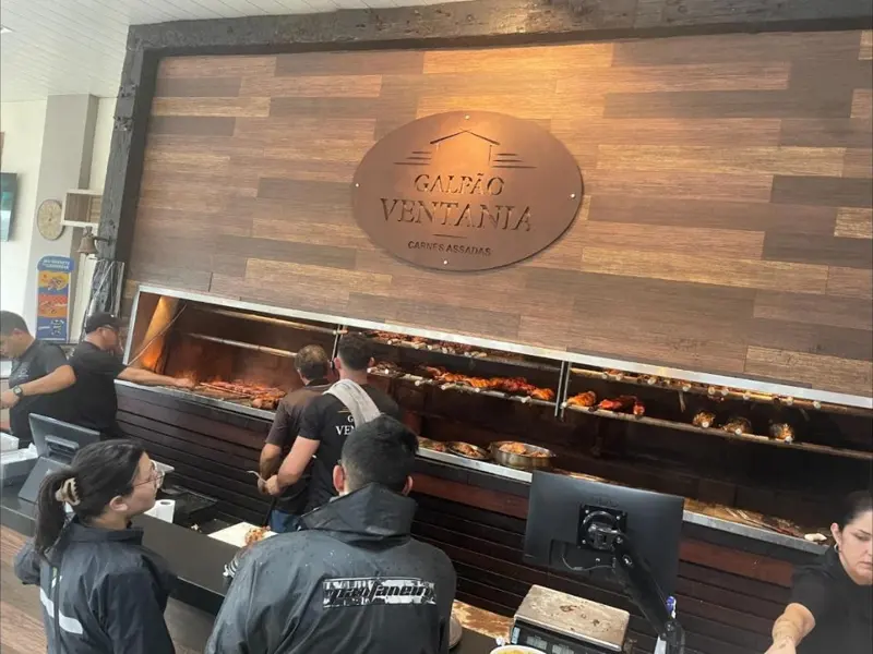 Assadores cuidando das carnes no braseiro do Galpão Ventania